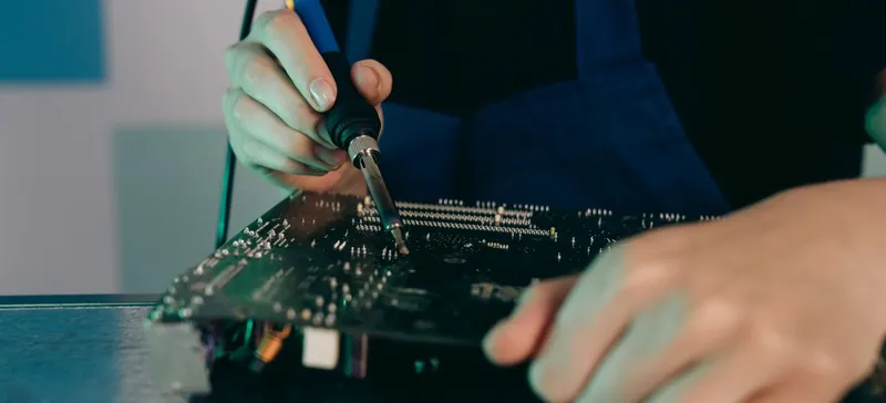 Stock photo: hands soldering components on a circuit board